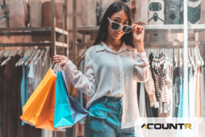 Woman shopping in a clothing store, holding colorful bags