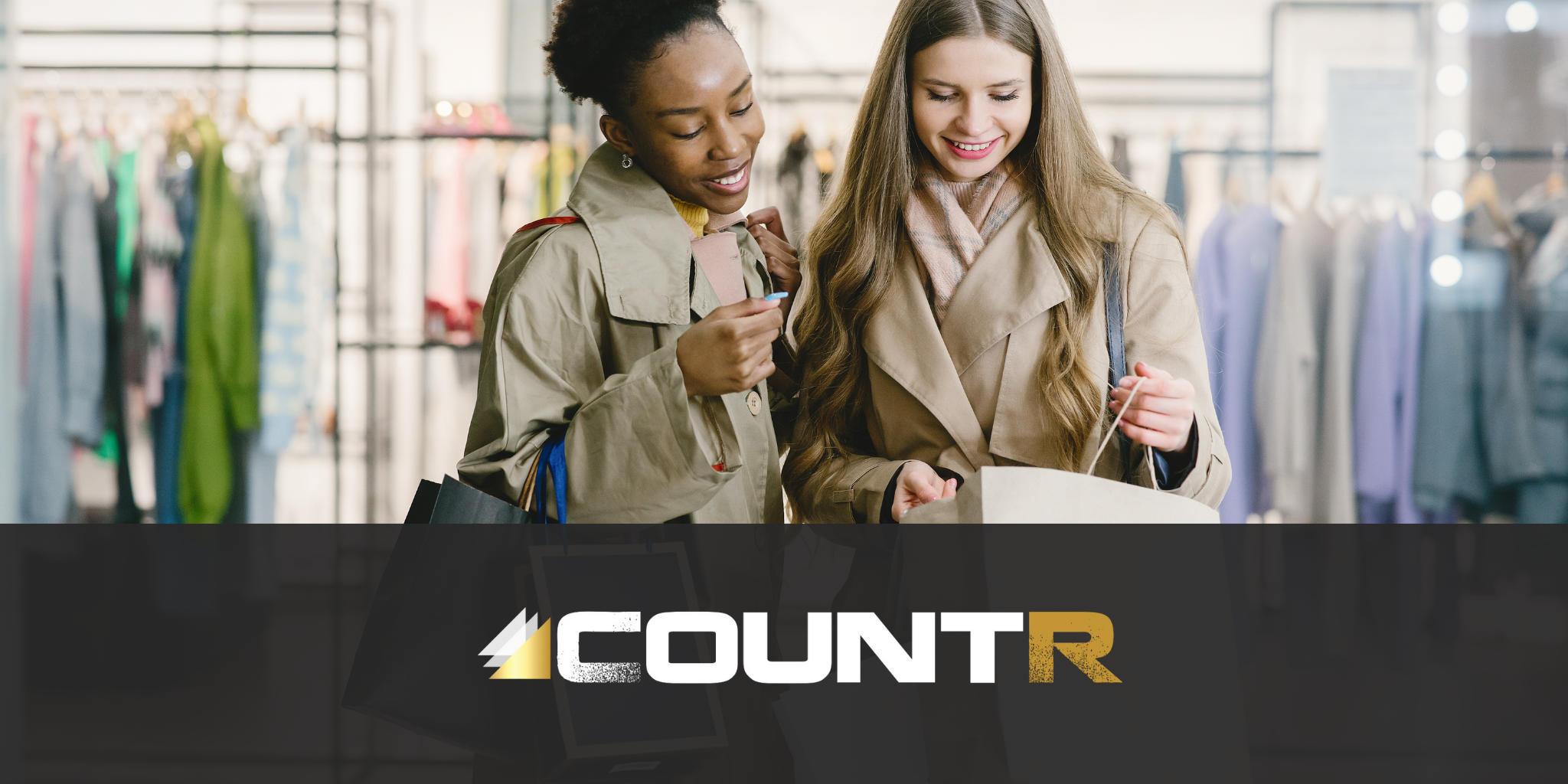 Two smiling women shopping in a fashion store, symbolizing improved customer engagement enabled by CountR footfall analytics