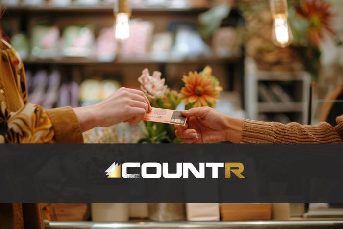 close-up of two people exchanging a payment card in a boutique store while Countr collects footfall data
