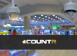 Close-up of security cameras in a retail store with CountR logo overlay.