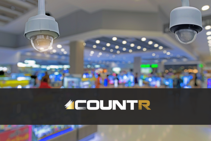 Close-up of security cameras in a retail store with CountR logo overlay.