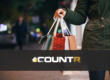 Person holding multiple shopping bags during the holiday season with CountR logo overlay