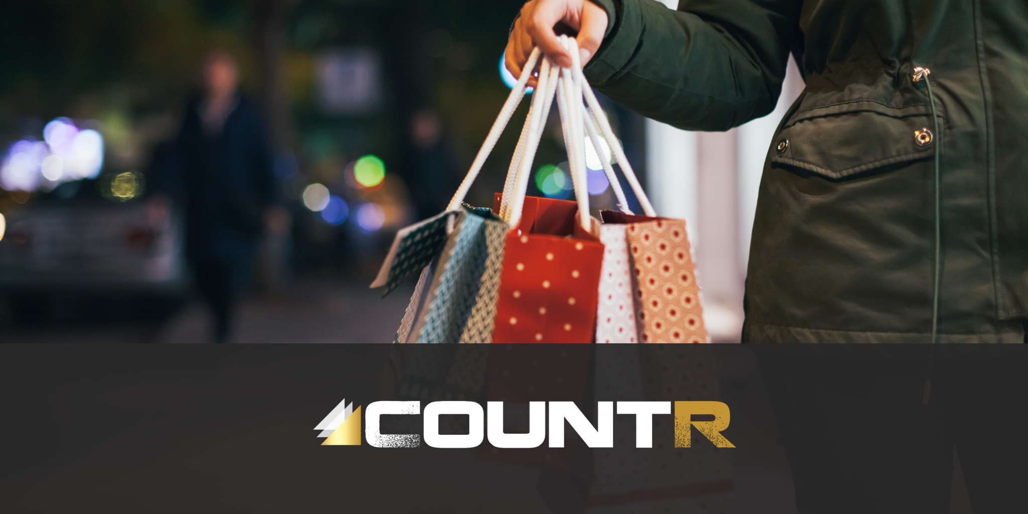 Person holding multiple shopping bags during the holiday season with CountR logo overlay