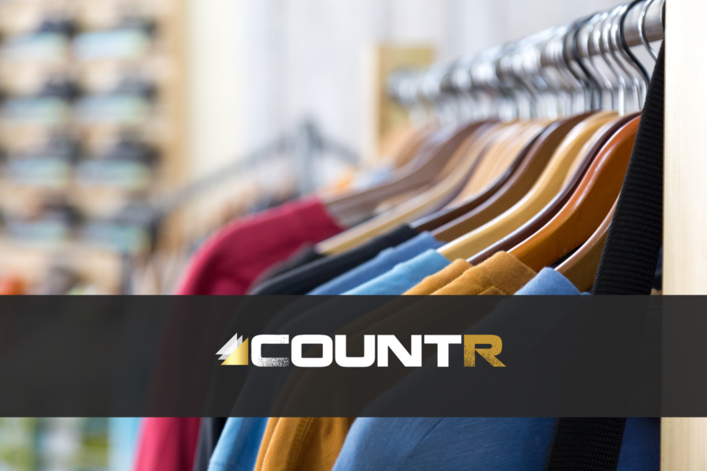 Clothing store rack with colorful shirts and the CountR logo representing reliable people counting systems.
